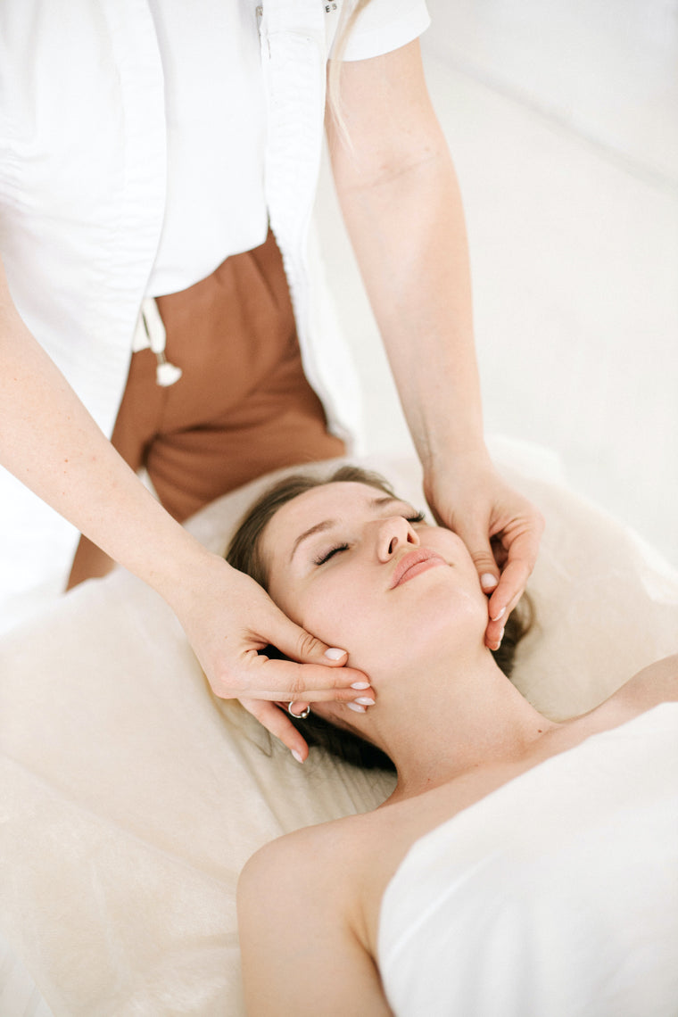 a female receiving a facial and massage in a beauty salon